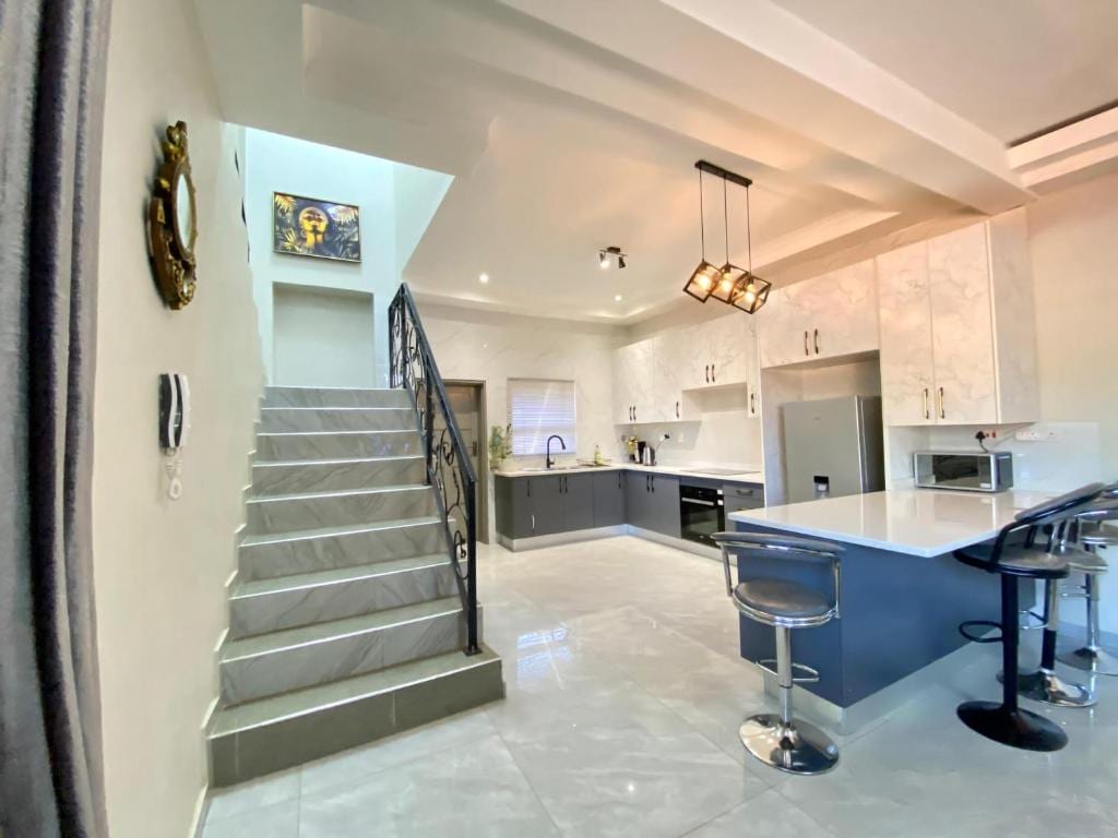 A Rhinoz Den home — open-plan staircase and kitchen